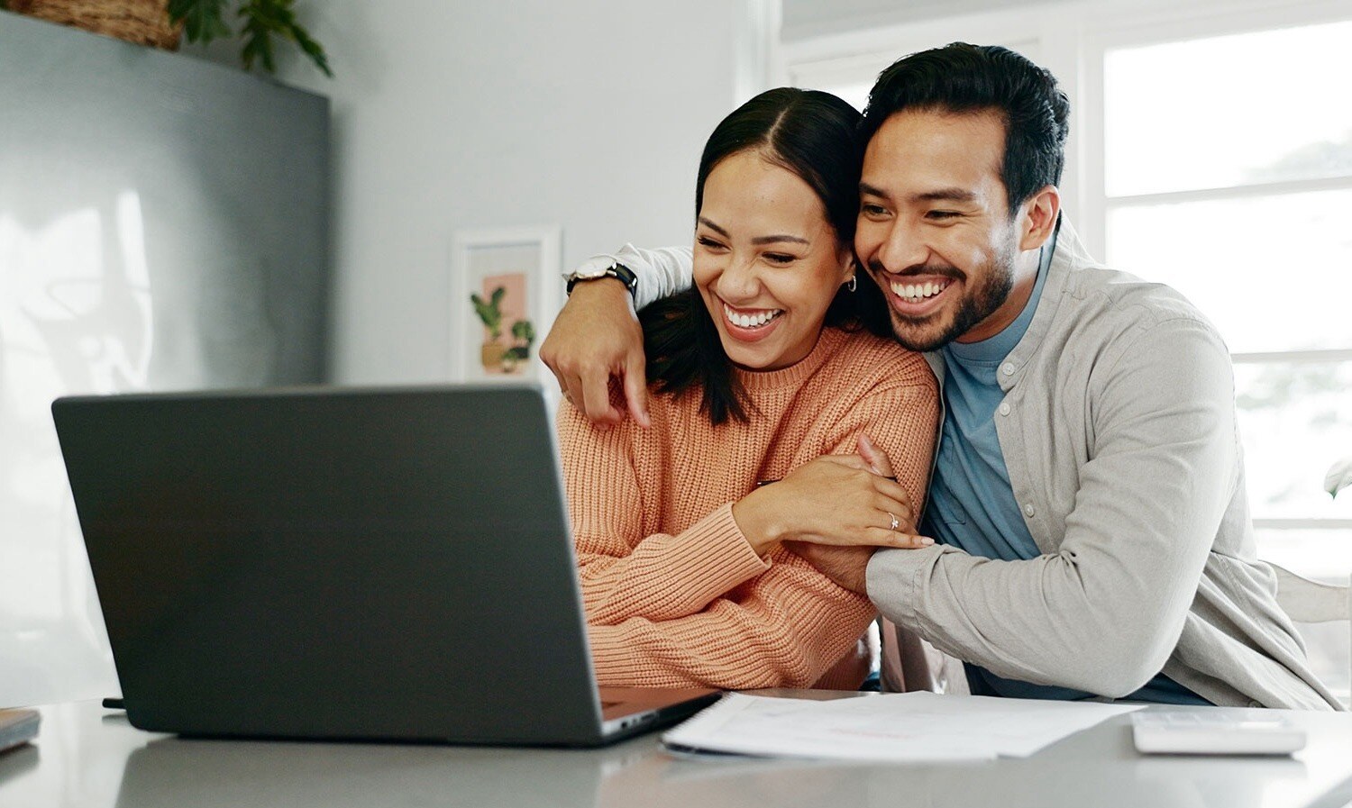 Happy couple looking at their computer and reviewing their financial goals.