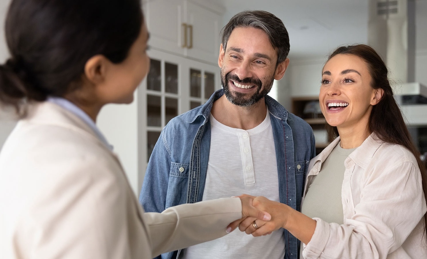 Man and woman meeting with another woman. Women are shaking hands.