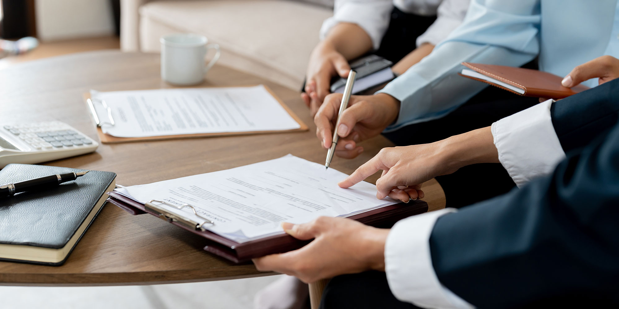 hands gather to examine a loan document