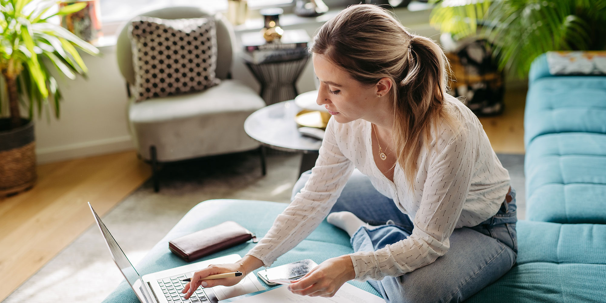 Woman writing stuff down and working on her laptop