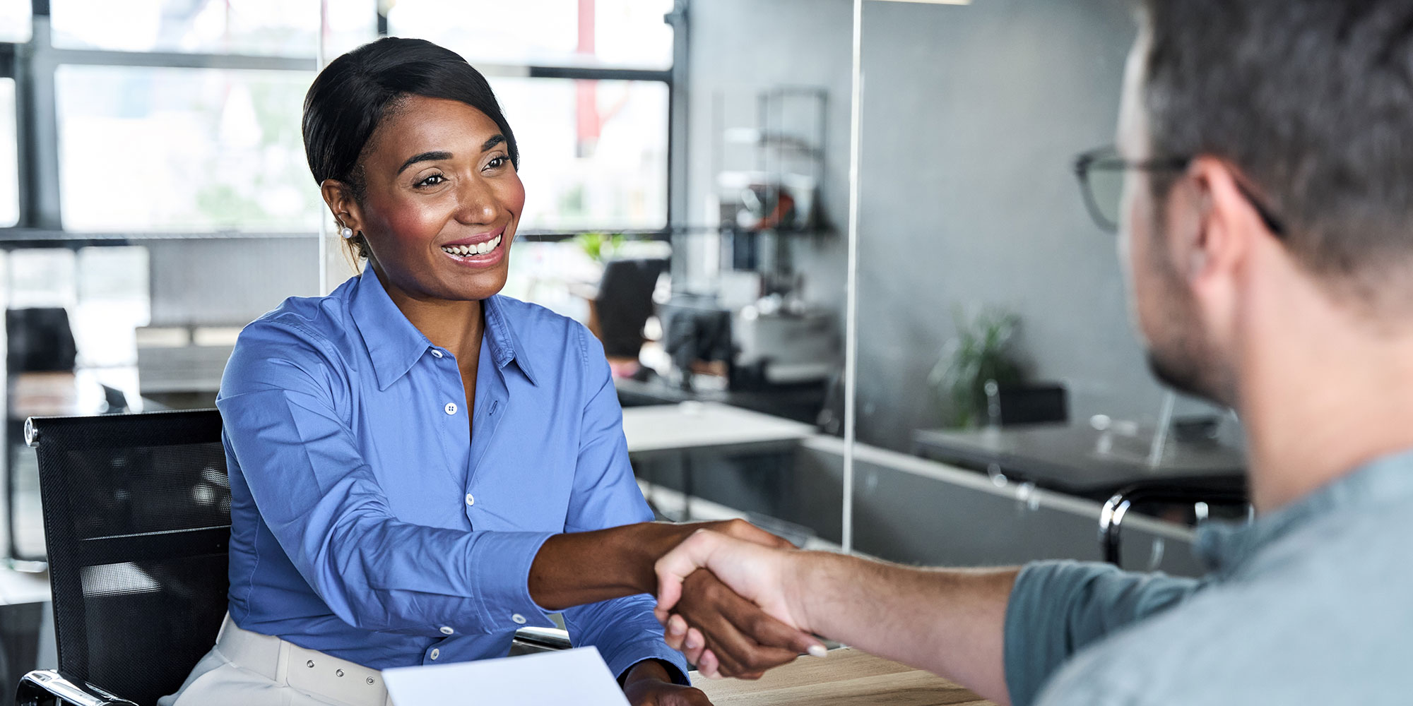 woman shaking hands over a document