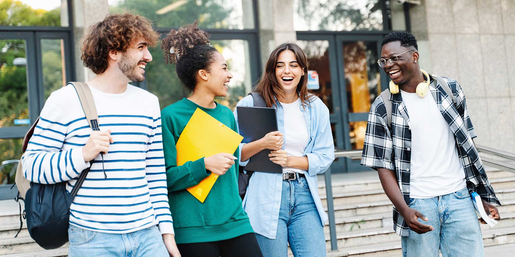 Group of college students with books in hands, walking. 