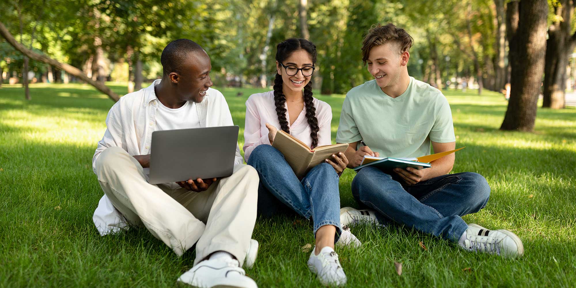Group of college students sitting on lawn.