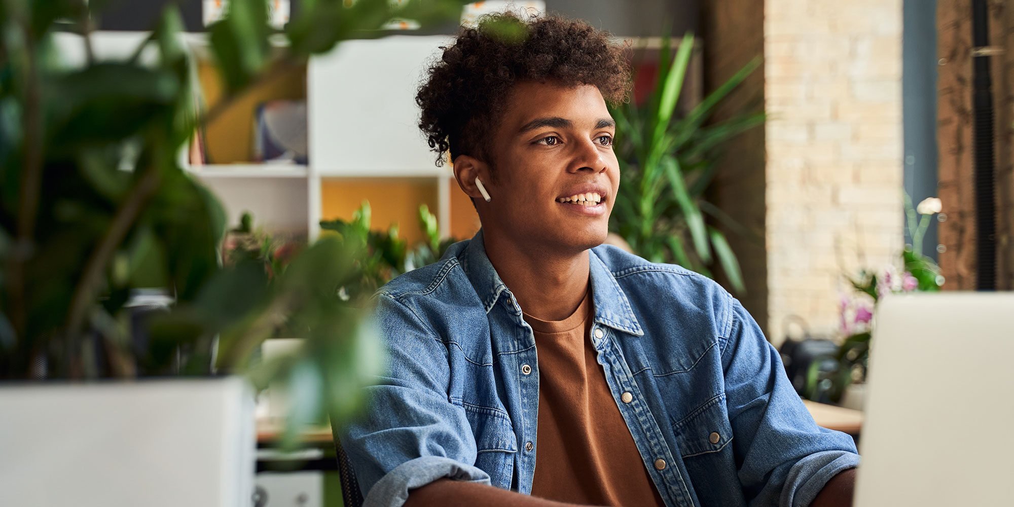 Teenage man with AirPods in looking in the distance. 