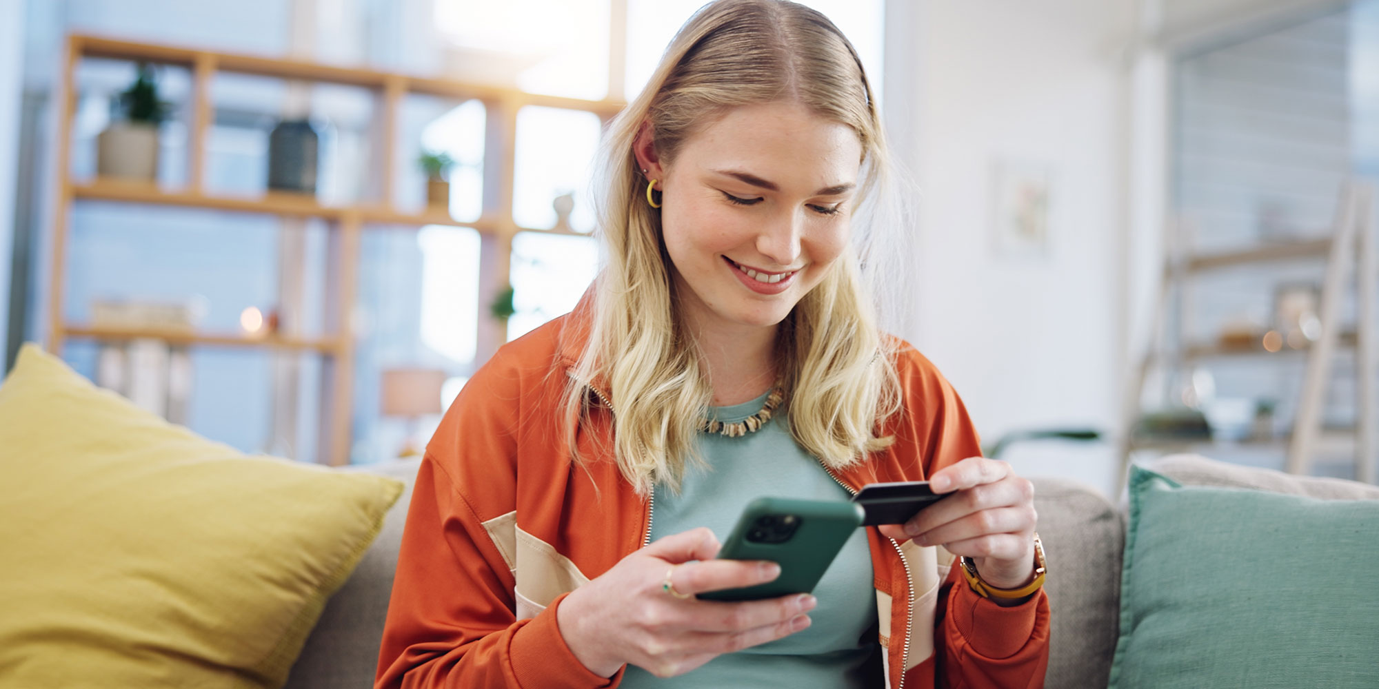Girl holding her credit card and her phone. 