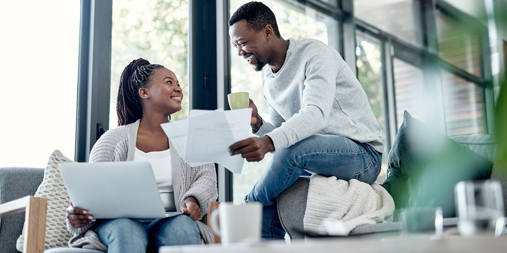 Smiling couple reviews financial documents together at home.