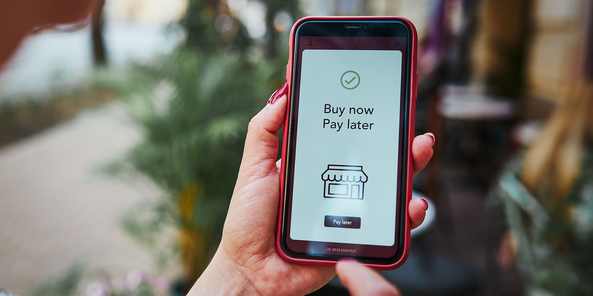 Hand holding phone with buy now pay later options on the screen